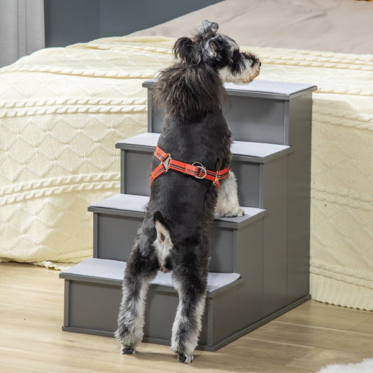 A small dog climbing the grey pet steps to reach a bed