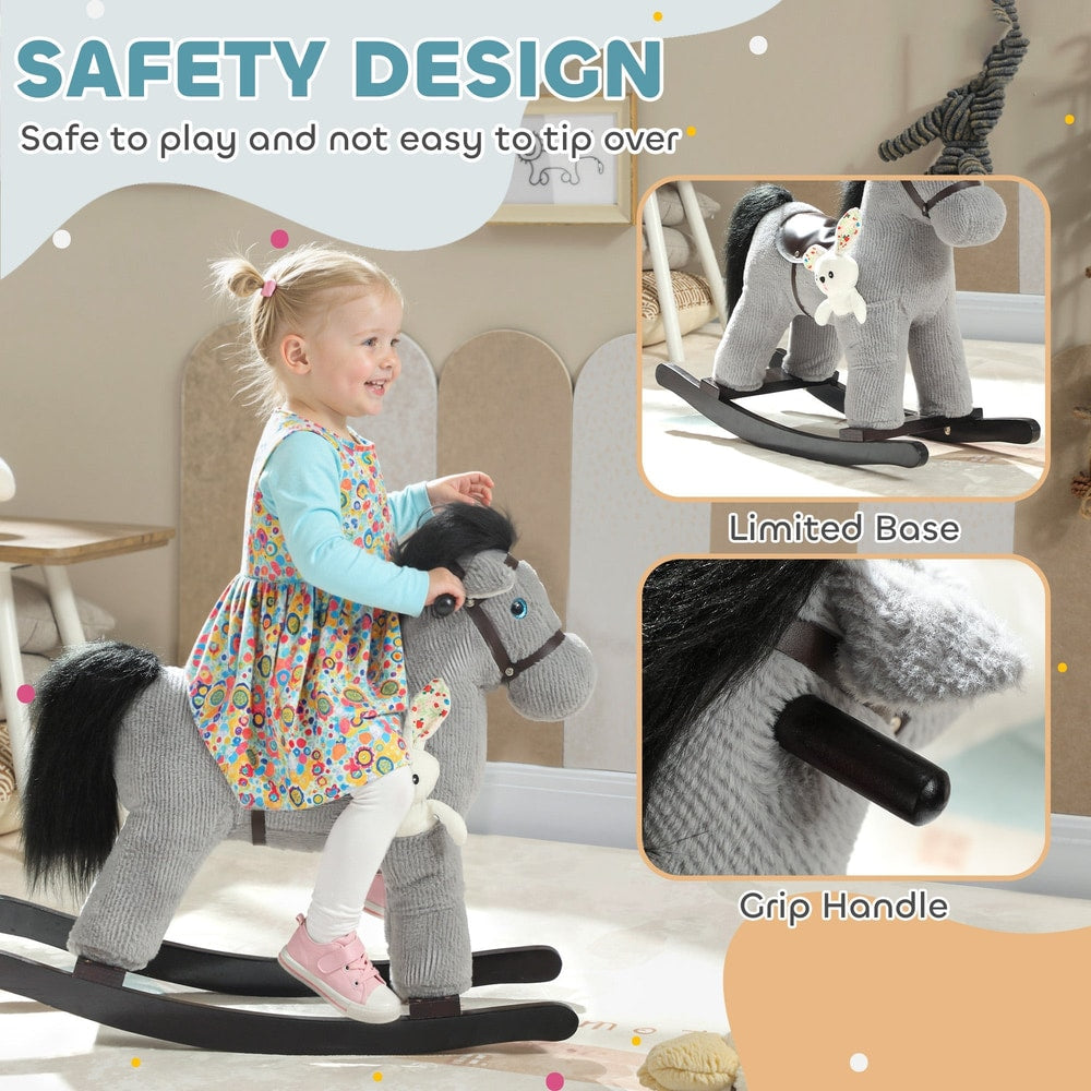 A toddler girl sits on a grey plush rocking horse with a focus on the safety design and grip handle