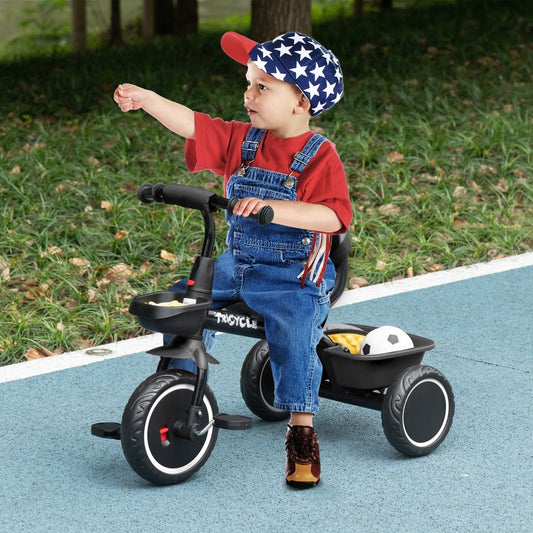 A young child in denim overalls riding the black kids trike on a blue outdoor path