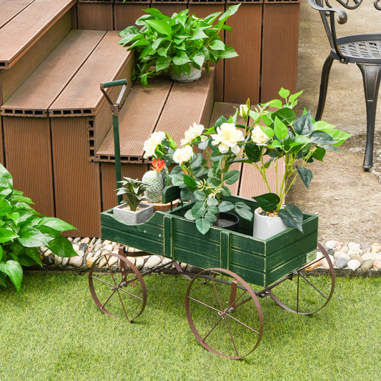 Green wooden wagon plant stand with wheels, filled with potted plants on a wooden deck