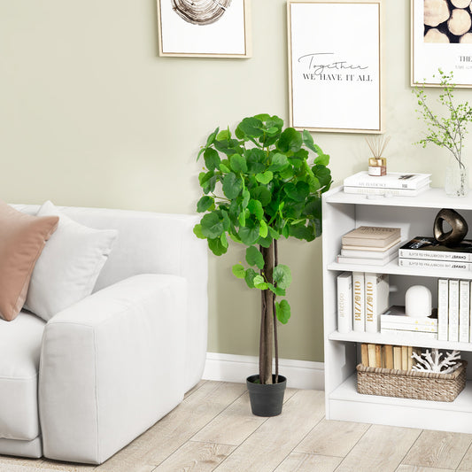 The faux plant in its pot is placed next to a sofa and bookshelf