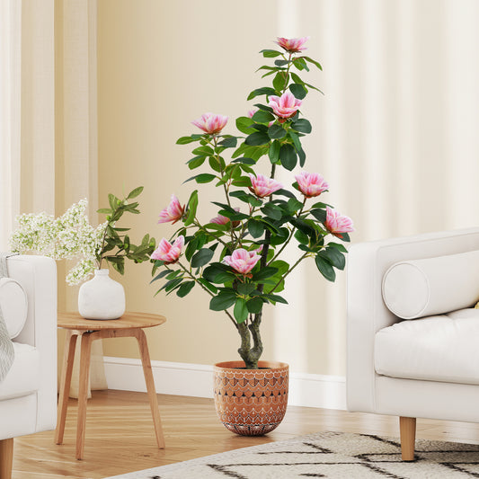 The faux plant placed in a patterned pot between two white sofas in a bright living room