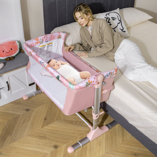 The bedside sleeper is next to a bed with a baby inside and a woman sitting on the bed