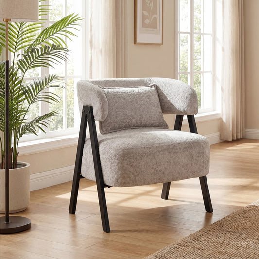 Grey upholstered armchair with black legs and lumbar pillow in a bright room