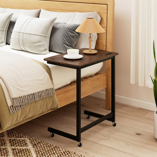 The mobile bedside table positioned next to a bed with a lamp and coffee cup