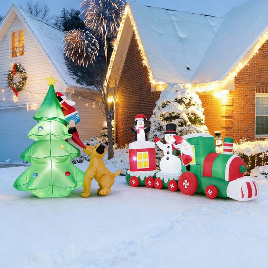 The Christmas inflatable decoration set in use on a snowy lawn at dusk with house lights