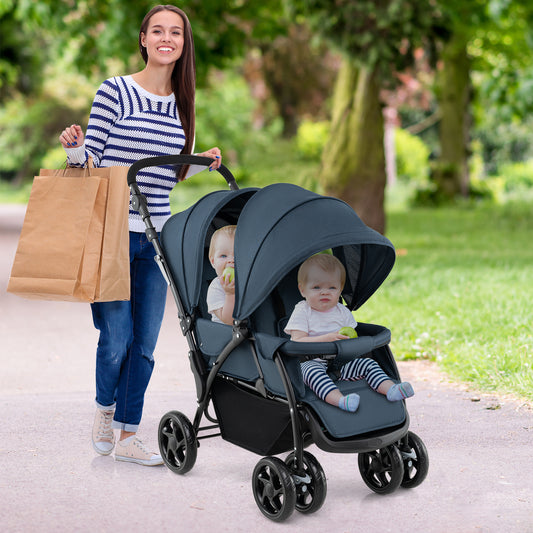 A woman pushes the blue double pushchair with two babies sitting inside while walking outdoors