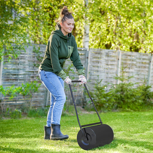 A woman uses a garden lawn roller on a grassy lawn outdoors