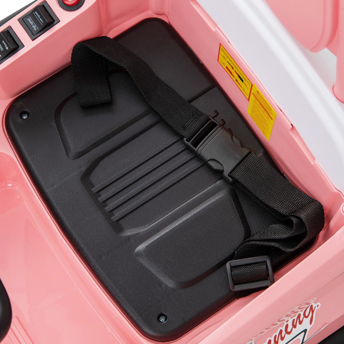 The black seat and safety harness inside the kids electric car