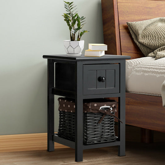Black wooden bedside table with a drawer and basket shelf next to a bed