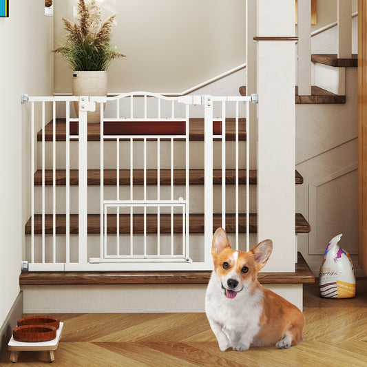 The white pet gate is mounted at the base of wooden stairs with a small dog sitting nearby