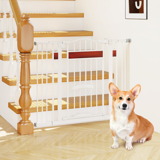 The extra wide pet gate is installed at the bottom of a wooden staircase with a corgi sitting in front of it
