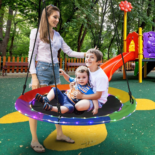 A mother and two children enjoy the colourful swing & playset in a garden playground
