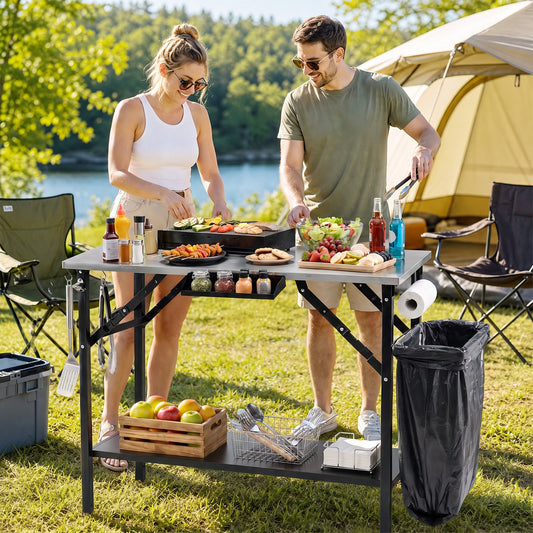 The outdoor grill station being used by a couple to prepare food at a campsite near a tent