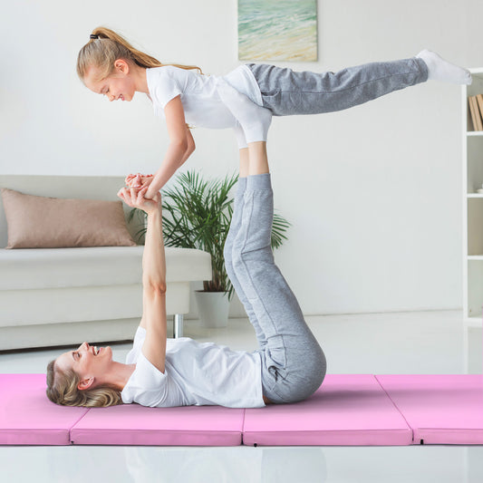 The pink folding gymnastics mat is shown laid out flat with two people doing an acrobatic pose on it
