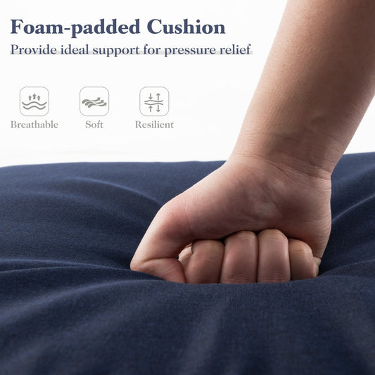 Close up of a hand pressing into the navy blue foam-padded outdoor furniture cushion