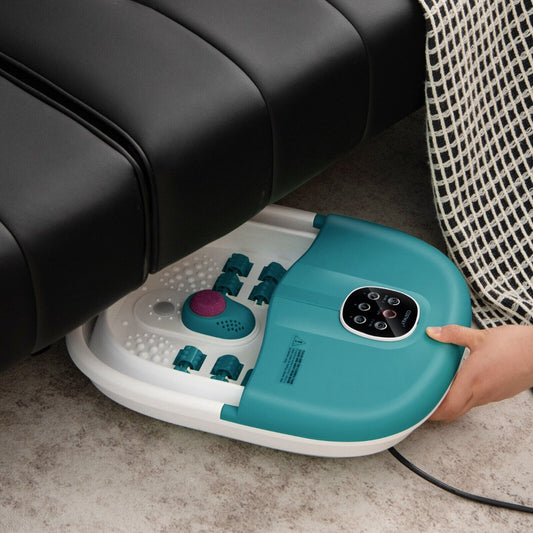 The foot massager being pushed under a black sofa by a hand