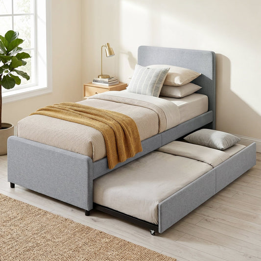 The upholstered pull out bed with trundle is set up in a bedroom with bedding and a plant