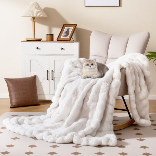The bedding draped over a cream armchair with a small cat sitting on top in a bright room