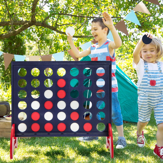 Two children playing the giant four-in-a-row lawn game outdoors