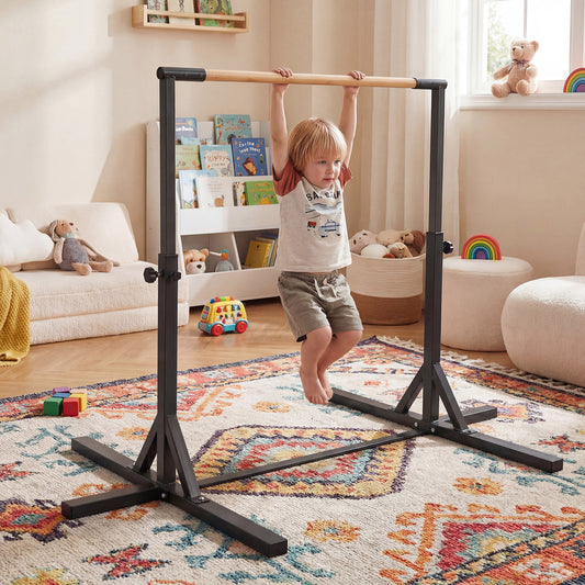 The yoga accessory set up in a child's bedroom with a boy hanging from the horizontal bar