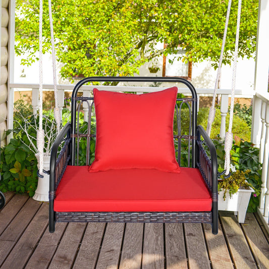 The porch swing suspended on a wooden deck with a lush green garden in the background