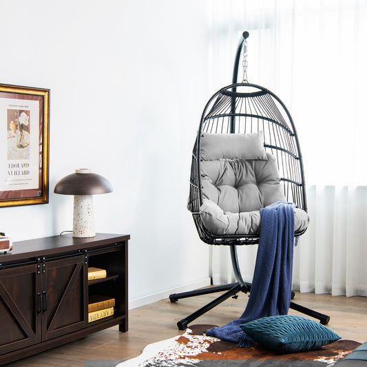 The hanging egg chair with stand and cushion placed in a living room next to a cabinet
