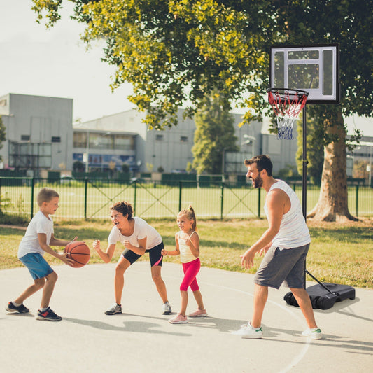 A family plays basketball together using the adjustable basketball hoop and stand outdoors on a paved court