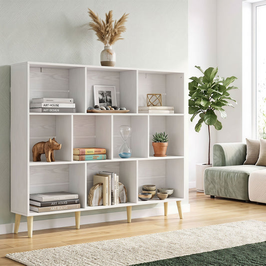 The white bookcase styled with books and decor in a bright living room setting