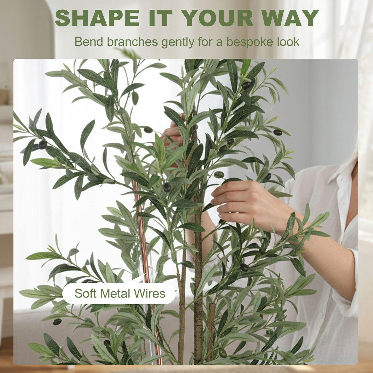 Hands adjusting the branches of the artificial plant to show the flexible metal wires inside