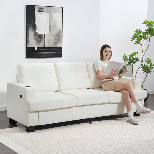 A woman sits on the cream white three-seater sofa, reading a magazine in a living room setting