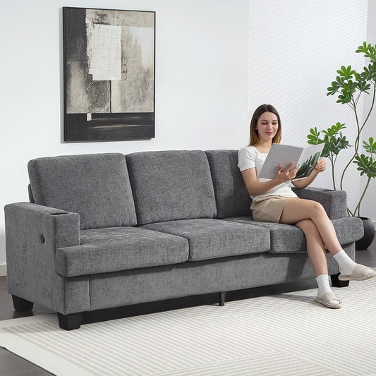 the grey sofa in a living room with a woman sitting and reading a book