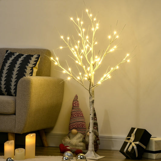 The artificial white birch tree light is displayed in a room with a sofa and festive decorations