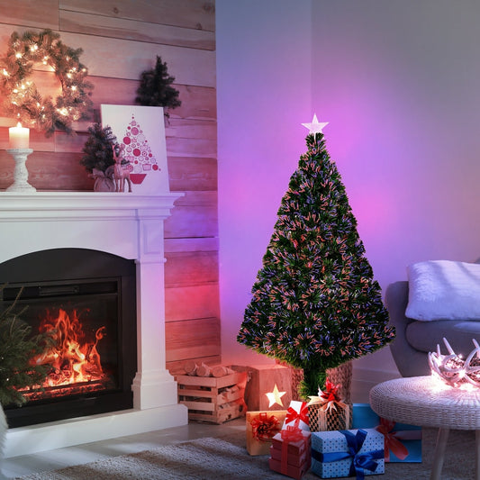 The fibre optic Christmas tree set up in a living room next to a fireplace with presents underneath