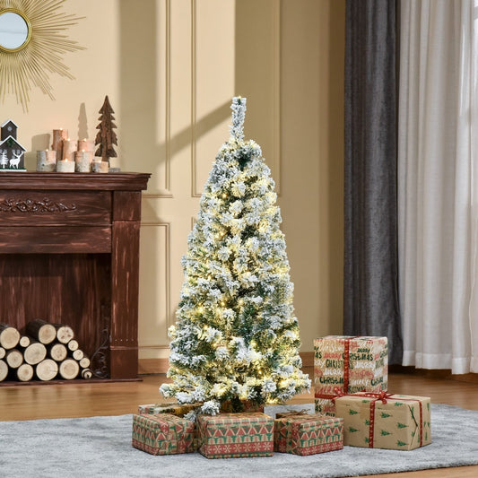 The snow flocked Christmas tree is decorated with presents in a cosy room setting