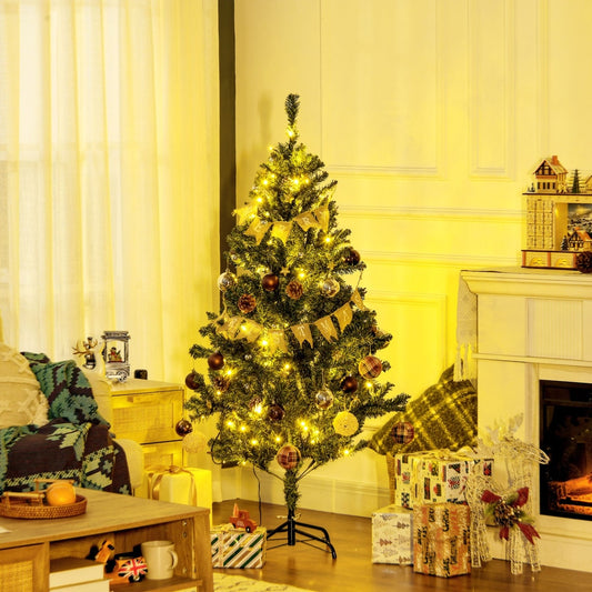 The artificial Christmas tree is set up in a cosy living room next to a fireplace