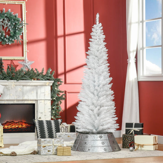 The white Christmas tree is set up in a room next to a fireplace and presents