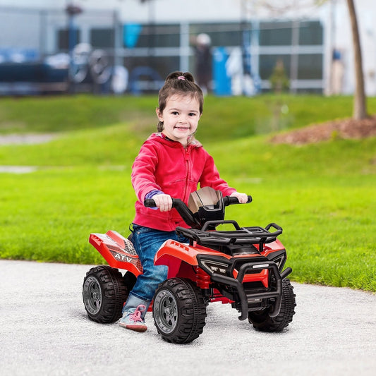 A young child sitting on the red electric quad bike on a paved path in a park