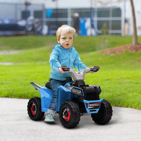 the blue kids quad bike being ridden on a paved path in a park
