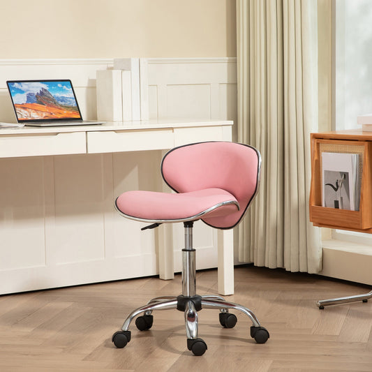 The pink beauty salon chair set up next to a desk with a laptop on it