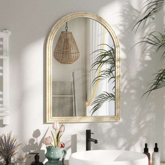 The wall mirror mounted above a bathroom sink with a plant and toiletries
