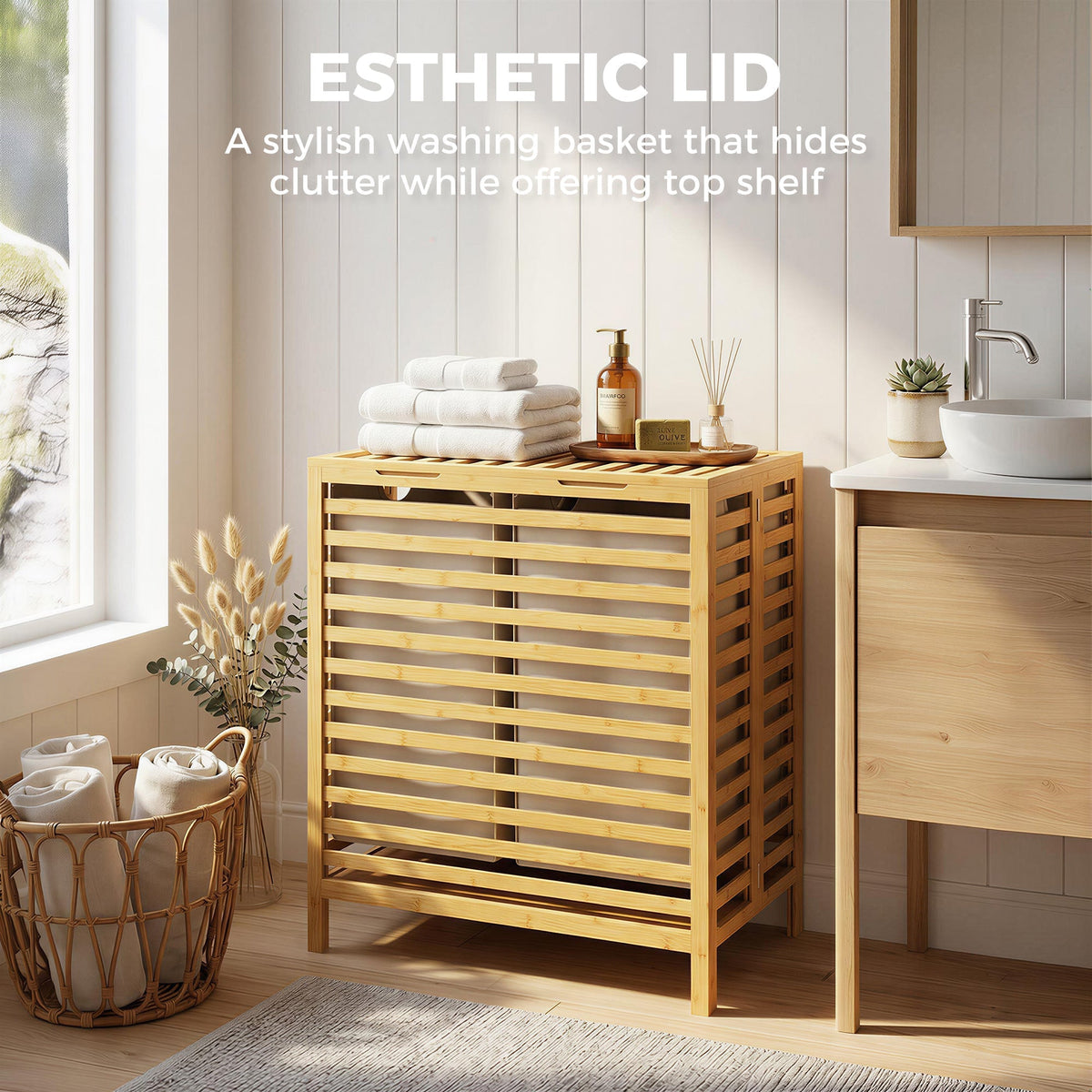 The laundry basket with the lid closed and items placed on top in a bright bathroom setting