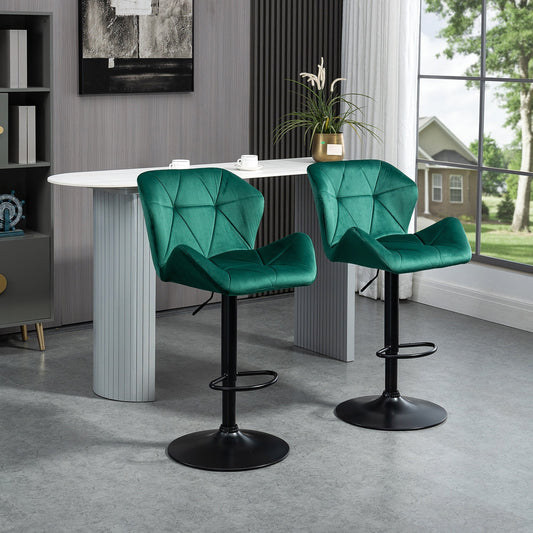 Two green velvet-touch bar stools in a modern kitchen setting next to a counter