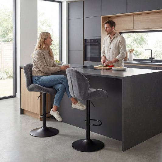 Two grey barstools with backs in a modern kitchen island setting with a couple seated