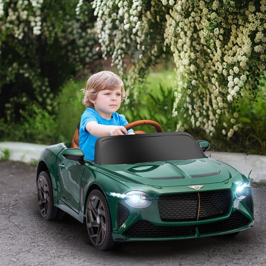 Young boy driving the green kids electric car on a paved path with flowers