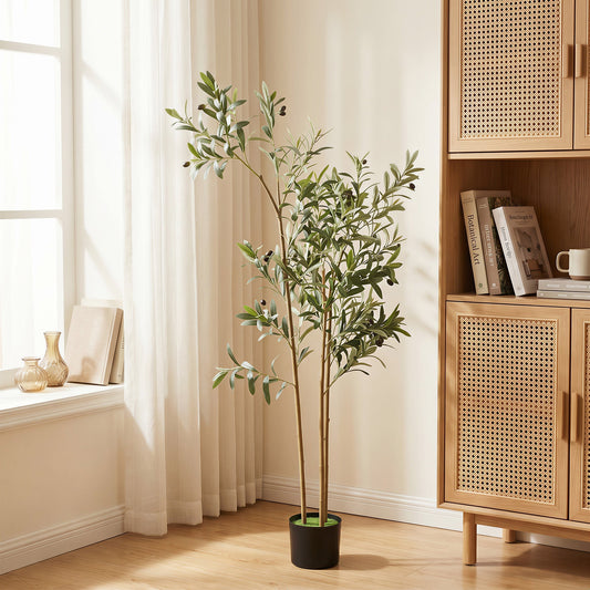 The artificial olive tree placed in a bright living room next to a wooden cabinet