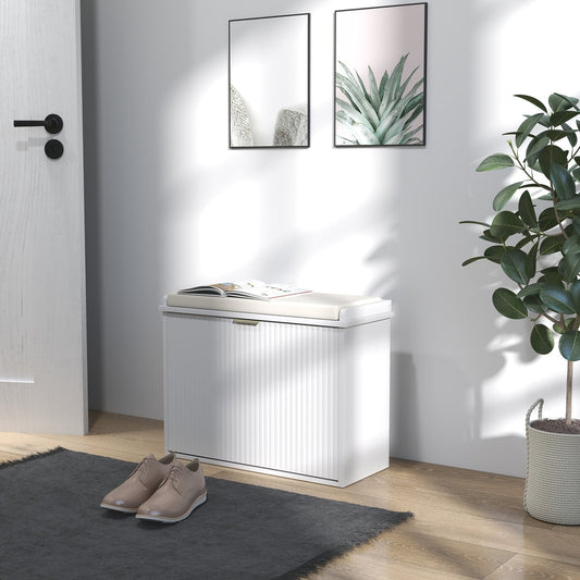 White shoe storage bench with a padded seat, placed in a hallway with shoes on the floor