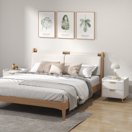 Two white bedside cabinets with gold handles and legs shown either side of a bed