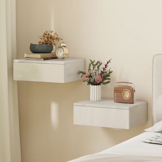 Two white floating bedside tables mounted on a wall above a bed