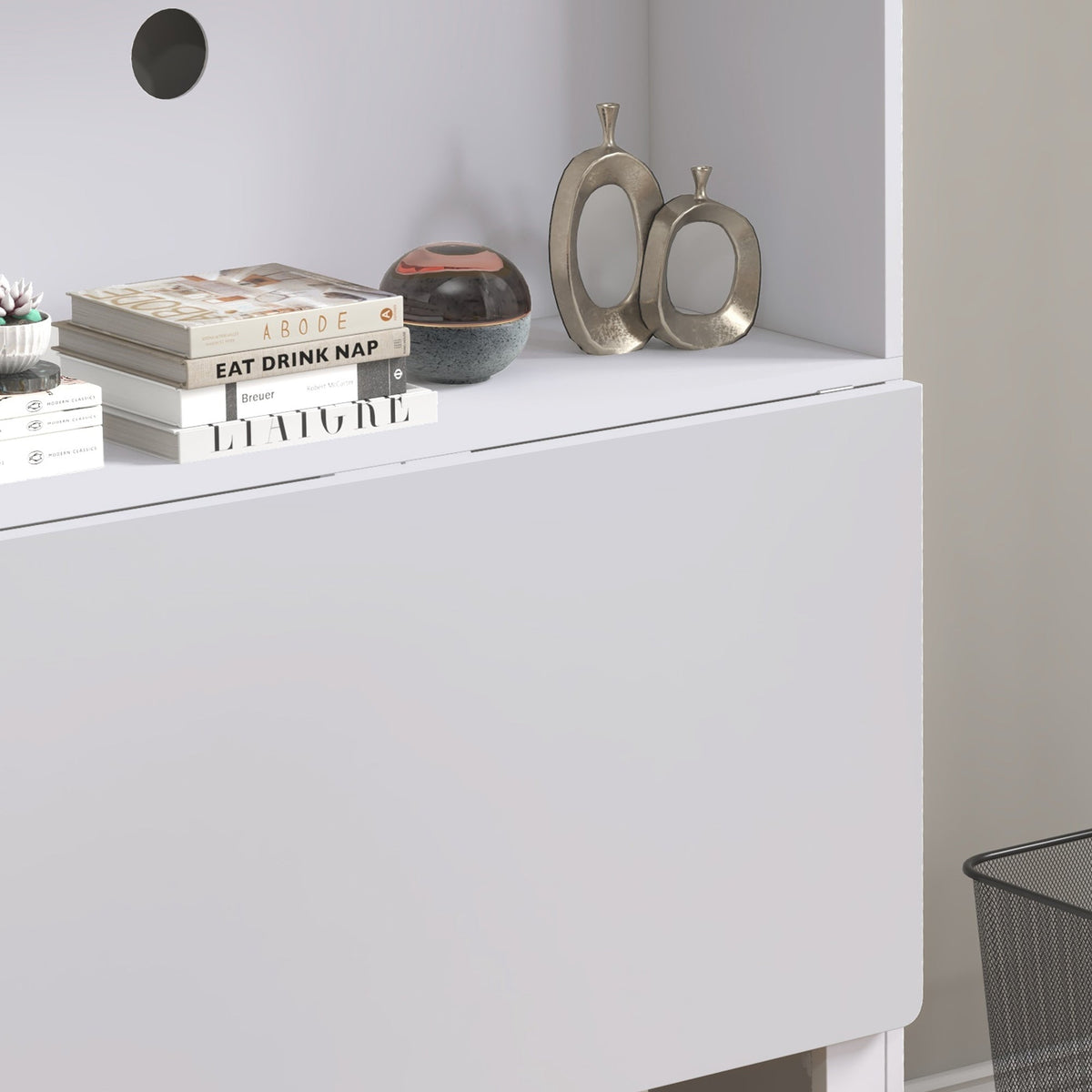 A close-up of the folded desk surface with books and ornaments placed on the top shelf